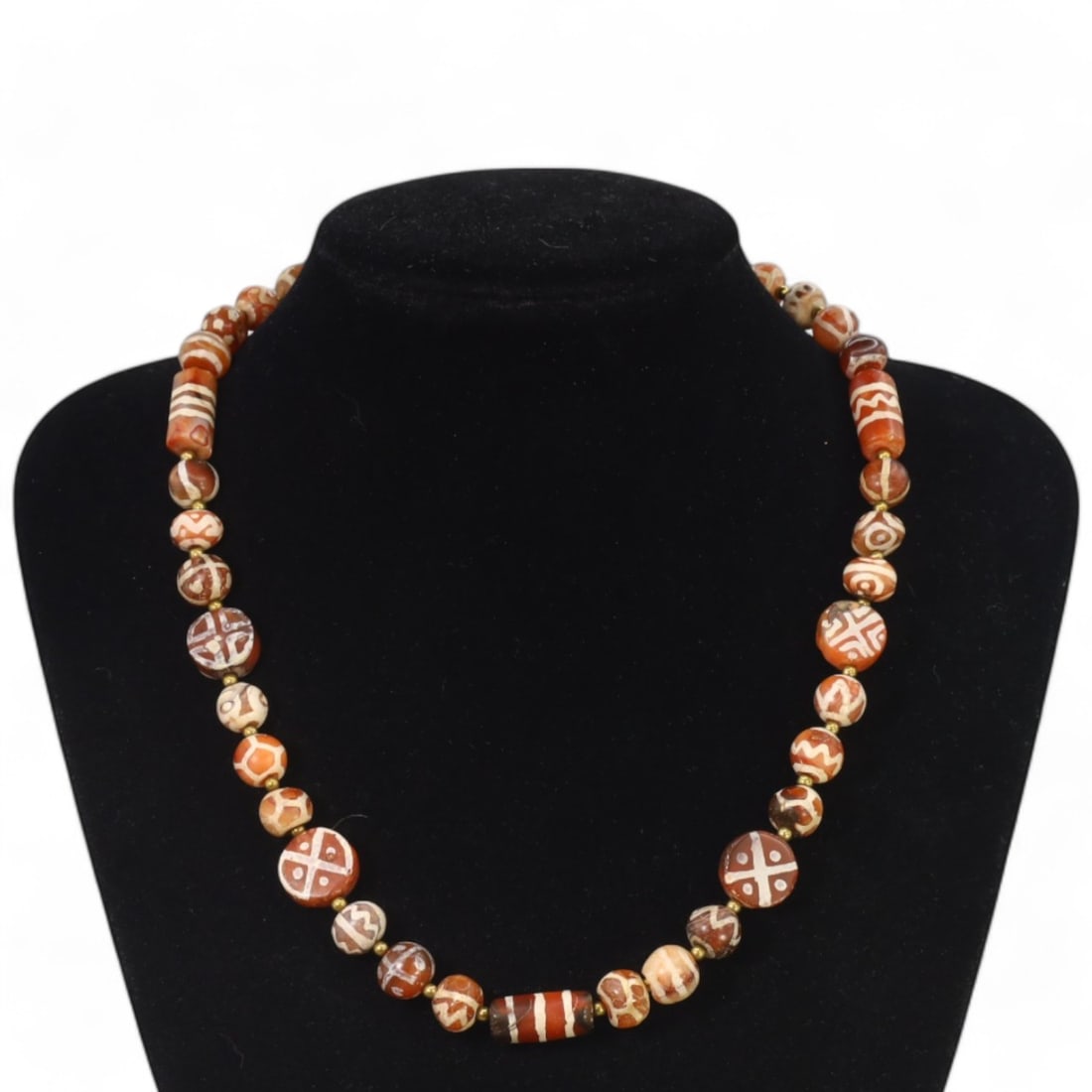 TIBETAN: Antique Etched Carnelian Dzi Beads Necklace, 19th-20th Century CE (48g, 55cm): This striking necklace features a strand of antique carnelian dzi beads, each intricately etched with traditional Tibetan motifs such as geometric patterns and eye designs, symbolizing protection and