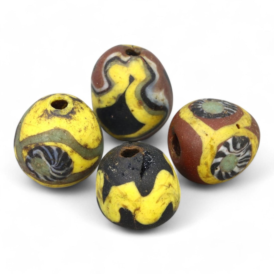 ANCIENT GLASS: Lot of 4 Roman Millefiori Glass Beads, 1st-3rd Century CE (15g, 14-18mm): This exceptional lot features four Roman millefiori ("thousand flowers") glass beads, ranging from 14-18mm in size, dating from the 1st-3rd century CE. Each bead showcases vibrant patterns of yellow, 
