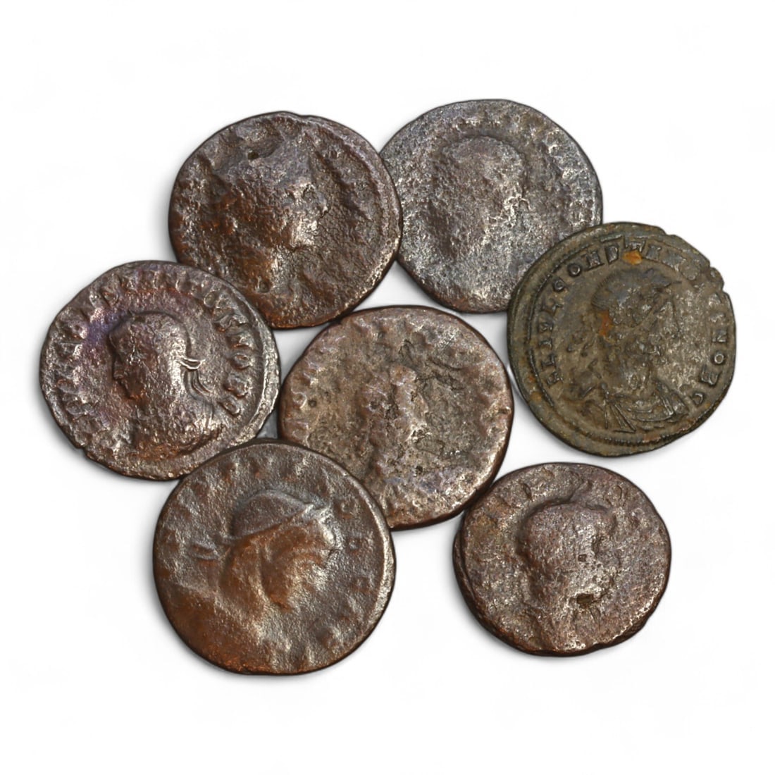 ROMAN EMPIRE: Lot of 7 Bronze Coins, 3rd-4th Century CE (18g Total, 19-20mm): This lot comprises 7 bronze Roman coins, collectively weighing 18 grams with diameters ranging from 19mm to 20mm. The obverse of each coin features a variety of imperial busts, showcasing Roman empero