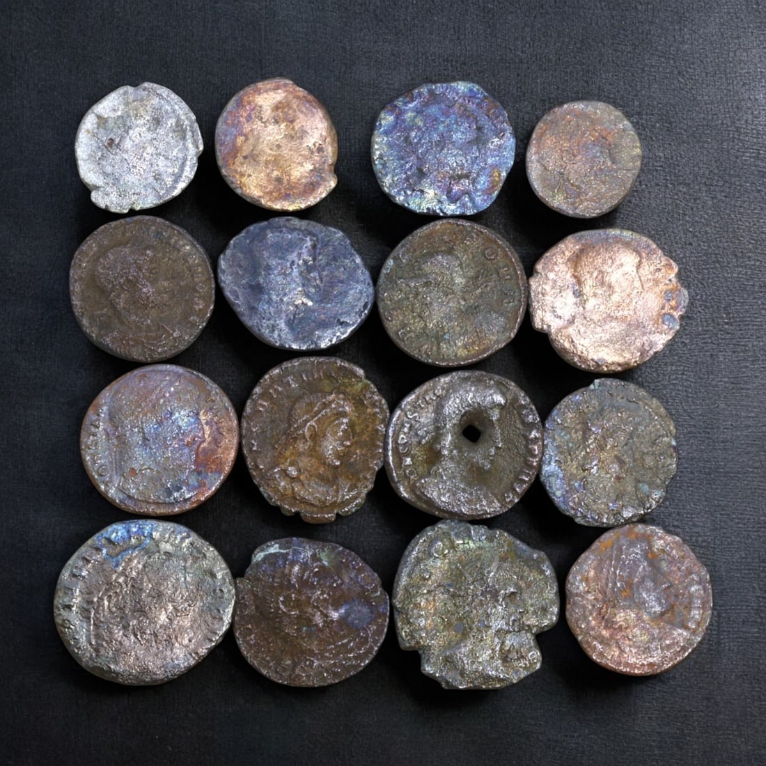 ROMAN BRONZE COIN LOT: Roman Imperial Period, Rome (29g, 13-20mm, 16 Pieces): This collection of 16 Roman bronze coins spans the Roman Imperial period, featuring various sizes and patinas that reflect centuries of circulation. Many coins exhibit portraits of emperors, deity fig