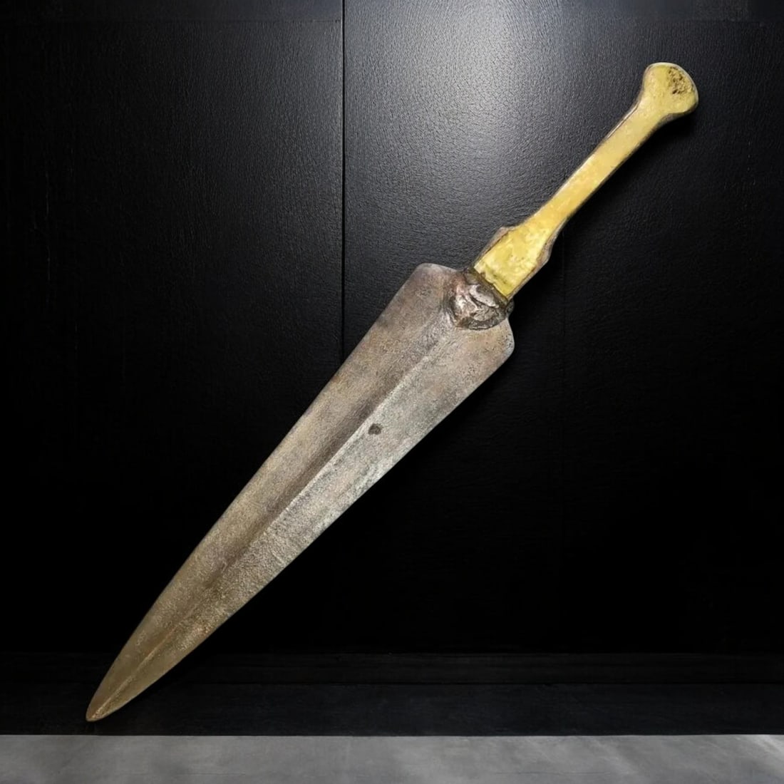 LURISTAN: Bronze Dagger with Tapered Blade and Bone Handle (178g, 35x5cm): This finely crafted Luristan bronze dagger features a long, tapered blade with a central ridge, designed for both piercing and slashing. The robust construction is characteristic of ancient Luristan w