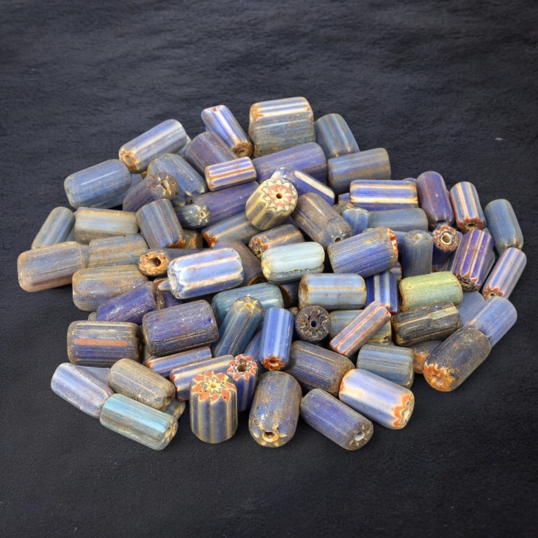 VENETIAN: Antique Millefiori Trade Beads, (49g, 1-2cm): This exceptional lot features Venetian antique millefiori trade beads, weighing a total of 49 grams with individual beads measuring between 1 and 2cm in size. These vibrant, cylindrical beads showcase