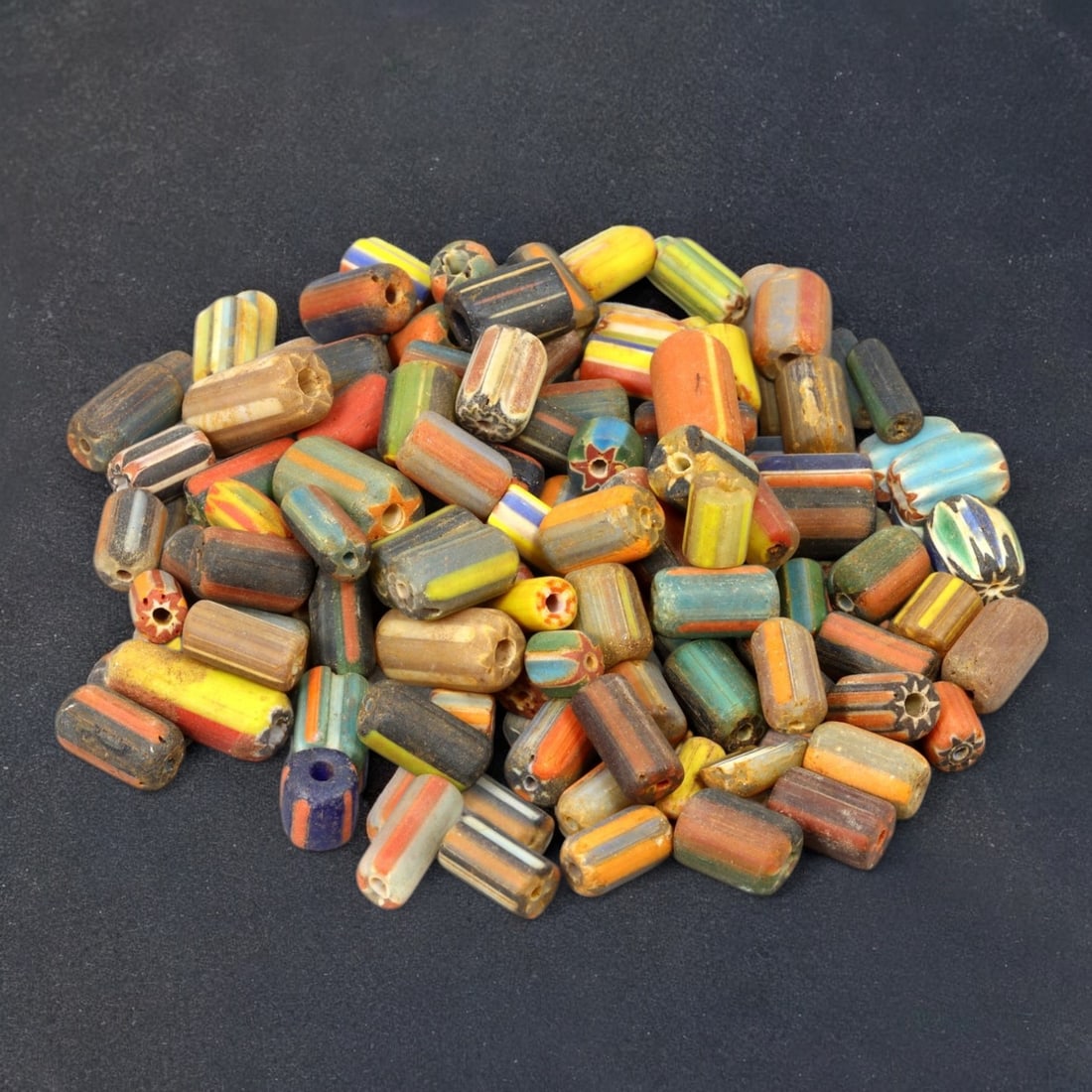 VENETIAN: Antique Millefiori Trade Beads, (78g, 1-2cm): This exceptional lot features Venetian antique millefiori trade beads, weighing a total of 78 grams with individual beads measuring between 1 and 2cm in size. These vibrant, cylindrical beads showcase