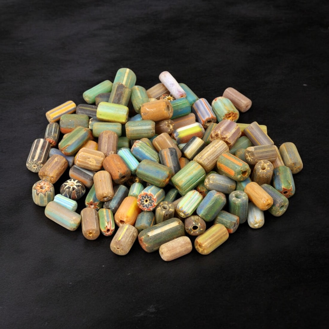 VENETIAN: Antique Millefiori Trade Beads, (73g, 1-2cm): This exceptional lot features Venetian antique millefiori trade beads, weighing a total of 73 grams with individual beads measuring between 1 and 2cm in size. These vibrant, cylindrical beads showcase