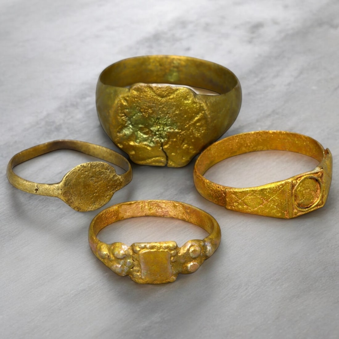 BYZANTINE ERA: Lot of Gilded Bronze Signet and Decorative Rings, 6th-10th Century CE (12g, 7-14 US): This captivating lot of Byzantine-era gilded bronze rings features an array of signet and decorative designs, professionally cleaned to reveal their original golden brilliance. The collection includes