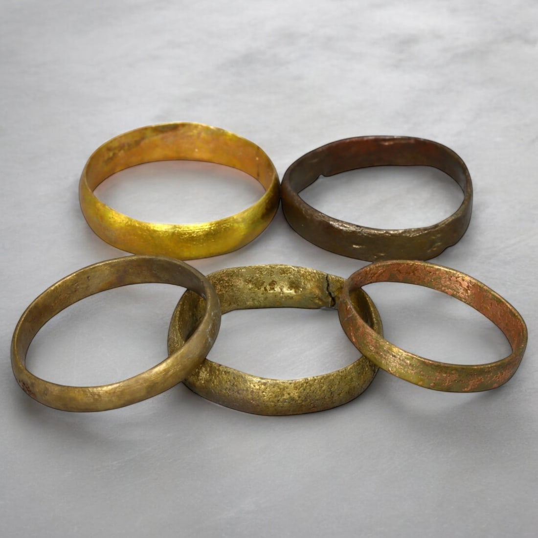 VIKING ERA: Lot of Bronze Solid Arm Rings, Circa 9th-11th Century CE (10g, Size 8-10 US, 5 pcs): This collection of Viking-era bronze solid arm rings features five distinct pieces, professionally cleaned to reveal their original golden bronze tones, accented by natural patinas. The robust, closed