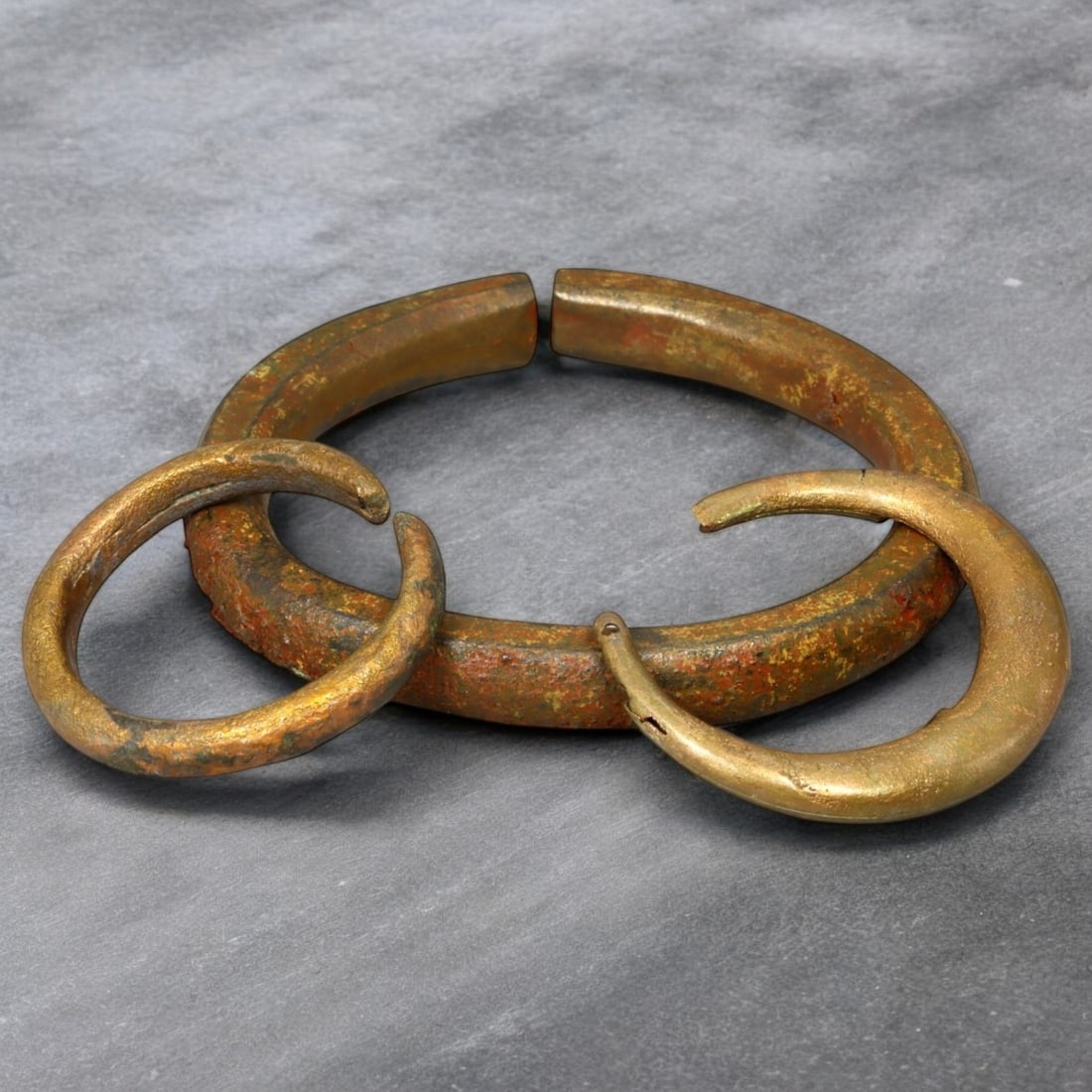 VIKING ERA: Bronze Penannular Arm Ring and Crescent Earrings, Circa 9th-11th Century CE (33g,: This striking set features a Viking-era bronze penannular arm ring paired with crescent-shaped earrings, professionally cleaned to reveal their original golden bronze luster. The arm ring’s robust, 