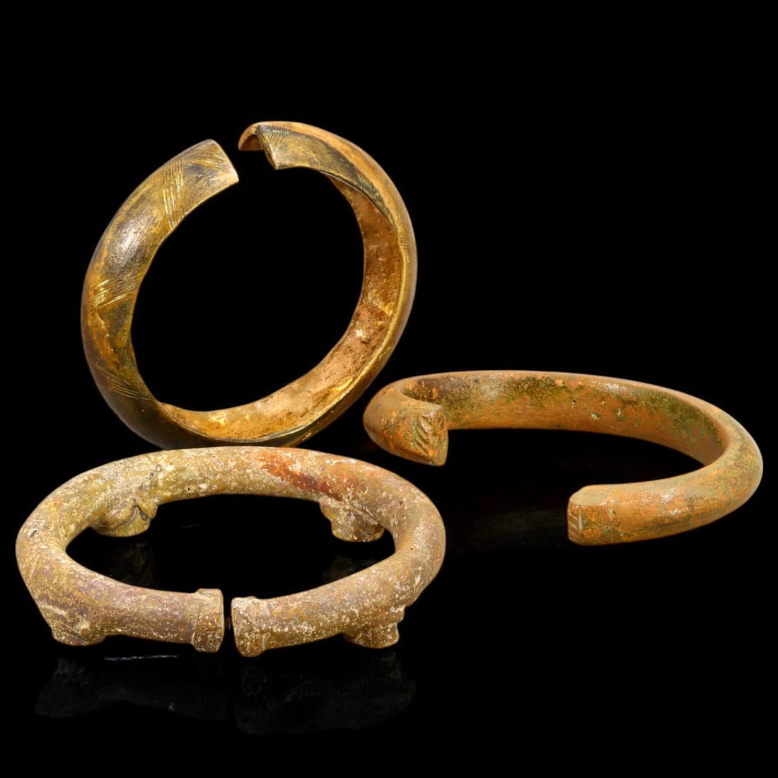 ANTIQUE BRONZE BRACELETS: Lot of Bronze Adornments (584g, 8-10cm): This lot features a collection of antique bronze bracelets, showcasing diverse styles and craftsmanship reflective of different cultural influences. The bracelets vary slightly in size and design, wit