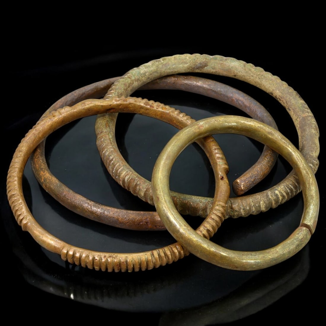 ANTIQUE BRONZE BRACELETS: Lot of Bronze Adornments (197g, 6-9cm): This lot features a collection of antique bronze bracelets, showcasing diverse styles and craftsmanship reflective of different cultural influences. The bracelets vary slightly in size and design, wit