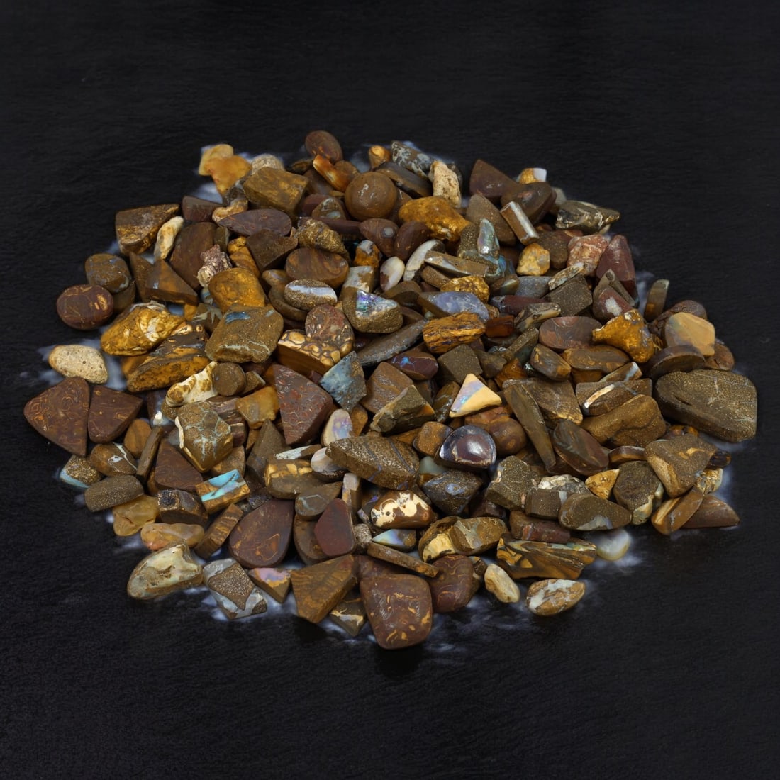 MATRIX BOULDER OPAL: Lot of Rough Opal, Queensland, Australia (639g, 1-3cm): This striking lot of matrix boulder opal rough hails from Queensland, Australia, renowned for its unique opal deposits. Weighing 639g, the stones range from 1 to 3cm, featuring vibrant flashes of blue
