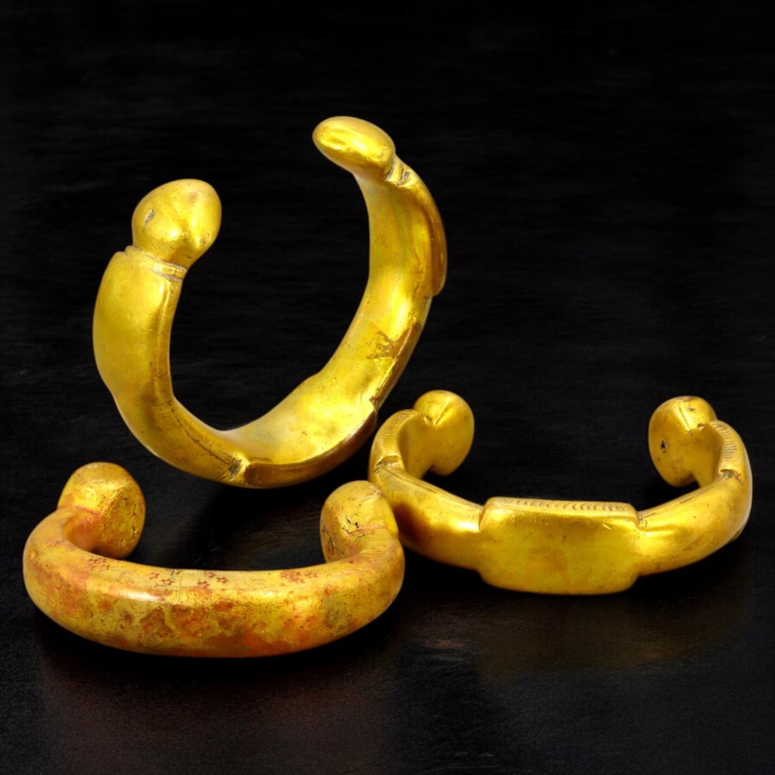 ANTIQUE BRONZE BRACELETS: Lot of Bronze Adornments (580g, 6-9cm): This lot features a collection of antique bronze bracelets, showcasing diverse styles and craftsmanship reflective of different cultural influences. The bracelets vary slightly in size and design, wit