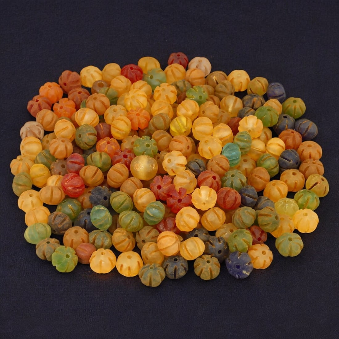 AFRICAN: Antique Carved Glass Beads, (256g, 12mm): This vibrant lot features African antique carved glass beads, with a total weight of 256 grams and individual beads measuring approximately 12mm in size. These intricately carved, multicolored beads r