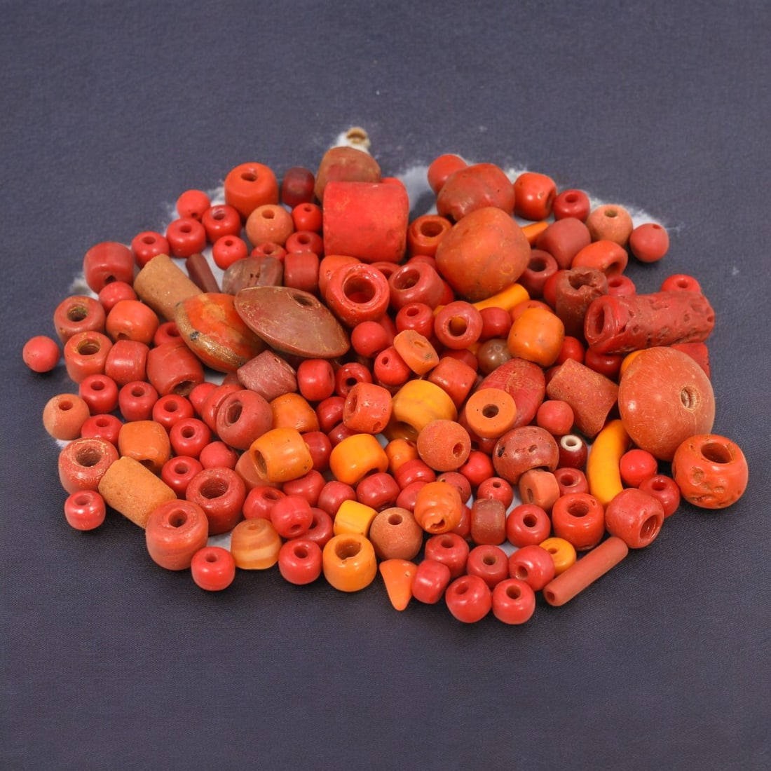 AFRICAN: Antique Red Coral Trade Beads, (11g, 6-115mm): This vibrant lot features African antique red coral trade beads, with a total weight of 11 grams and individual beads ranging from 6 to 115 mm in size. These beads display a rich spectrum of red and o