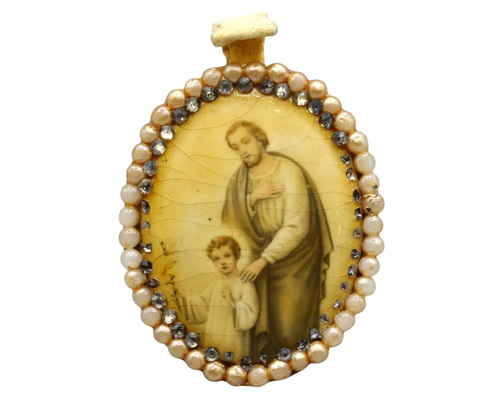 SPAIN: 19th-Century Reliquary Pendant - St. Joseph and Christ Child, Pearl and Rhinestone Frame: A delicate 19th-century Spanish devotional reliquary pendant featuring a finely printed image of St. Joseph with the Christ Child, encapsulated under convex glass. The border is adorned with natural s