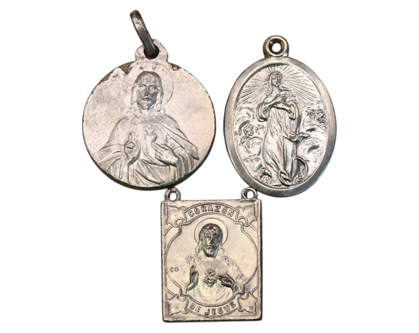 SPAIN: Sacred Heart & Marian Devotional Medals - Silver, 19th-20th Century: A set of three finely detailed silver devotional medals, measuring 2-2.5cm and weighing 9.6g, featuring religious iconography revered in Spanish Catholic tradition. The round medals depict the Sacred 