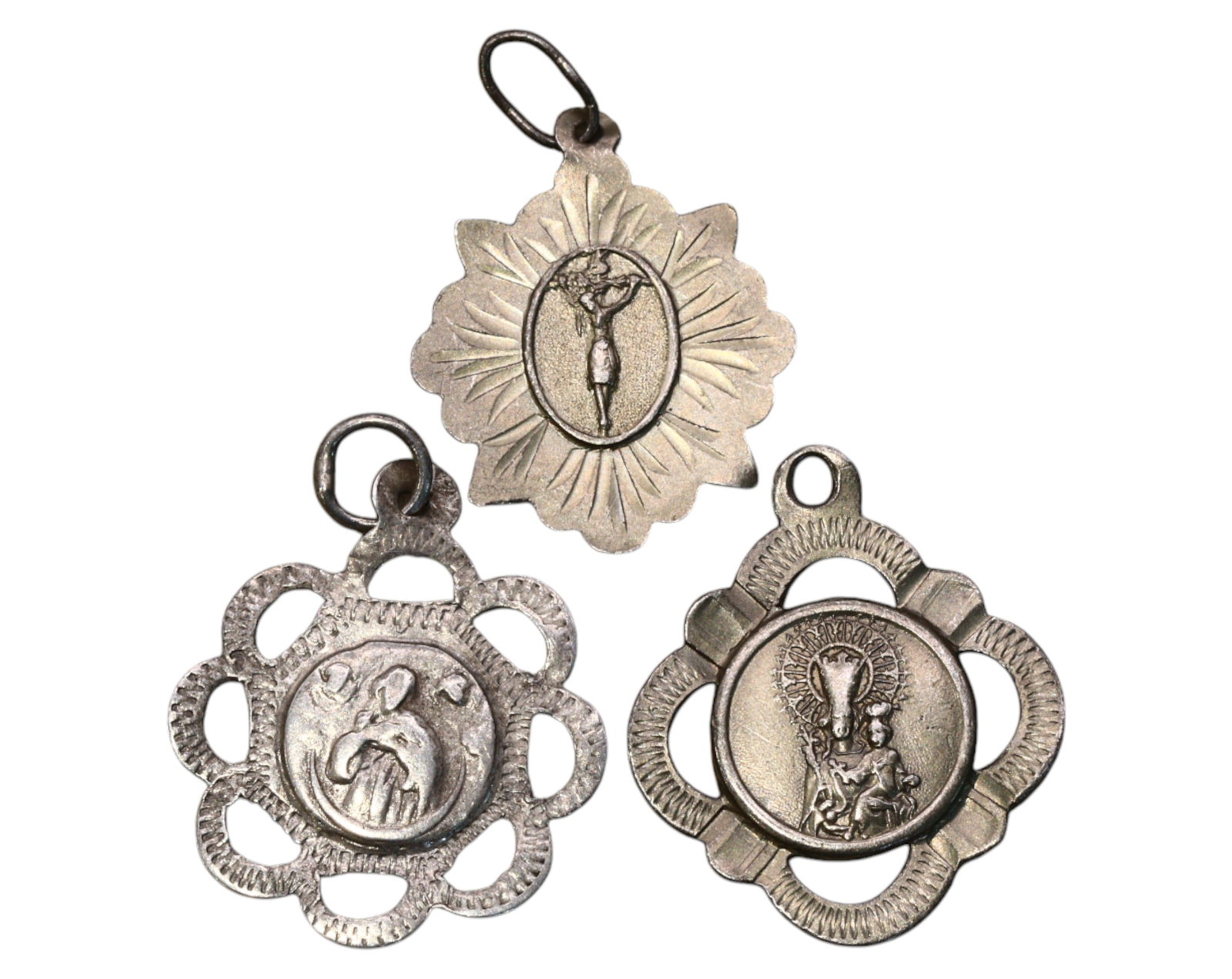 SPAIN: Religious Medals - Silver Devotional Pendants, 19th-20th Century: A trio of intricately designed Spanish religious medals, struck in silver, collectively weighing 3.2g and measuring between 2-2.3cm in diameter. These devotional pieces feature distinct openwork desig