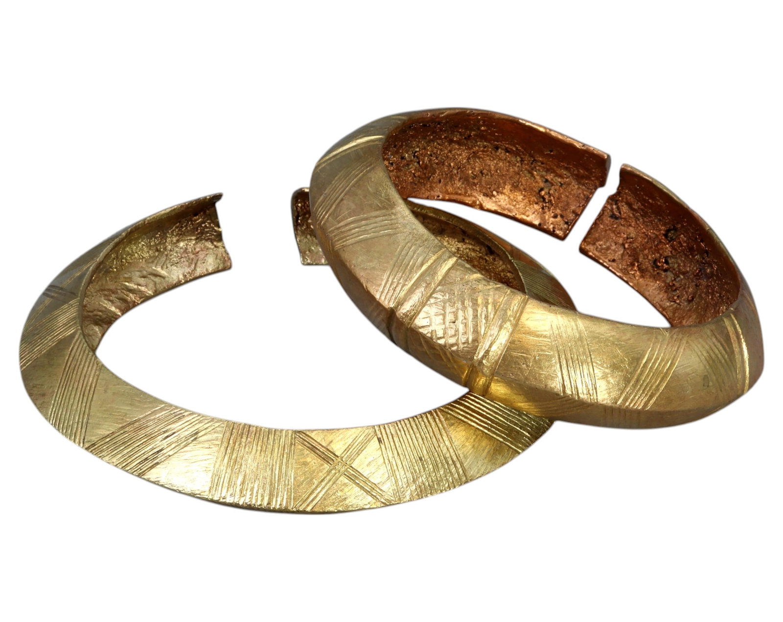 WEST AFRICA: Pair of Brass Currency Bracelets - Geometric Linework, 8.1-9.5cm, 219g: A matched pair of West African brass currency bracelets, each meticulously crafted with cross-hatched geometric line engravings across their broad surfaces. Measuring 8.1cm and 9.5cm in diameter, with