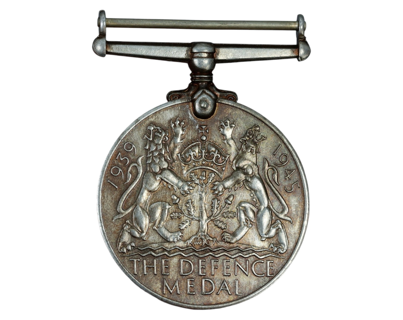 UNITED KINGDOM: WWII Defence Medal - Silver, 3.6x4.9cm, 32g, 1939-1945: A World War II Defence Medal, struck in silver, measuring 3.6 x 4.9 cm and weighing 32g. The obverse features a left-facing portrait of King George VI, encircled by the inscription "GEORGIVS VI D:G: B