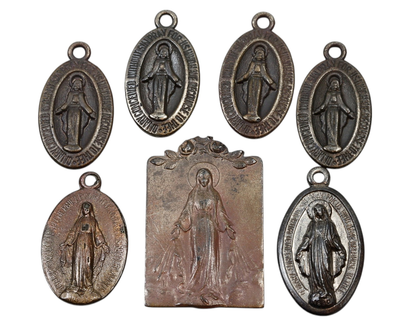 MIRACULOUS MEDALS - Virgin Mary Devotional Set, Mixed Metal, 7pcs, 19th-20th Century: A collection of seven Miraculous Medals featuring the iconic image of the Virgin Mary with rays of grace emanating from her hands, measuring approximately 2.1 to 2.8 cm and totaling 13.9g in weight. S
