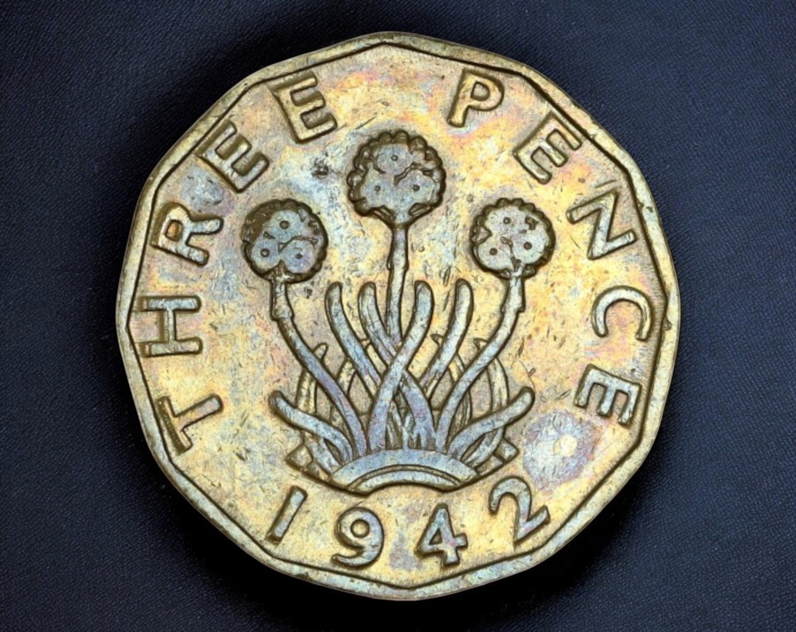 UNITED KINGDOM: George VI Brass Threepence Coin - 2.1cm, 6.7g, 1937-1952: A distinctive brass Threepence Coin coin from the reign of King George VI (1936-1952), measuring 2.1 cm in diameter and weighing 6.7g. The obverse features a left-facing portrait of the king, encircle