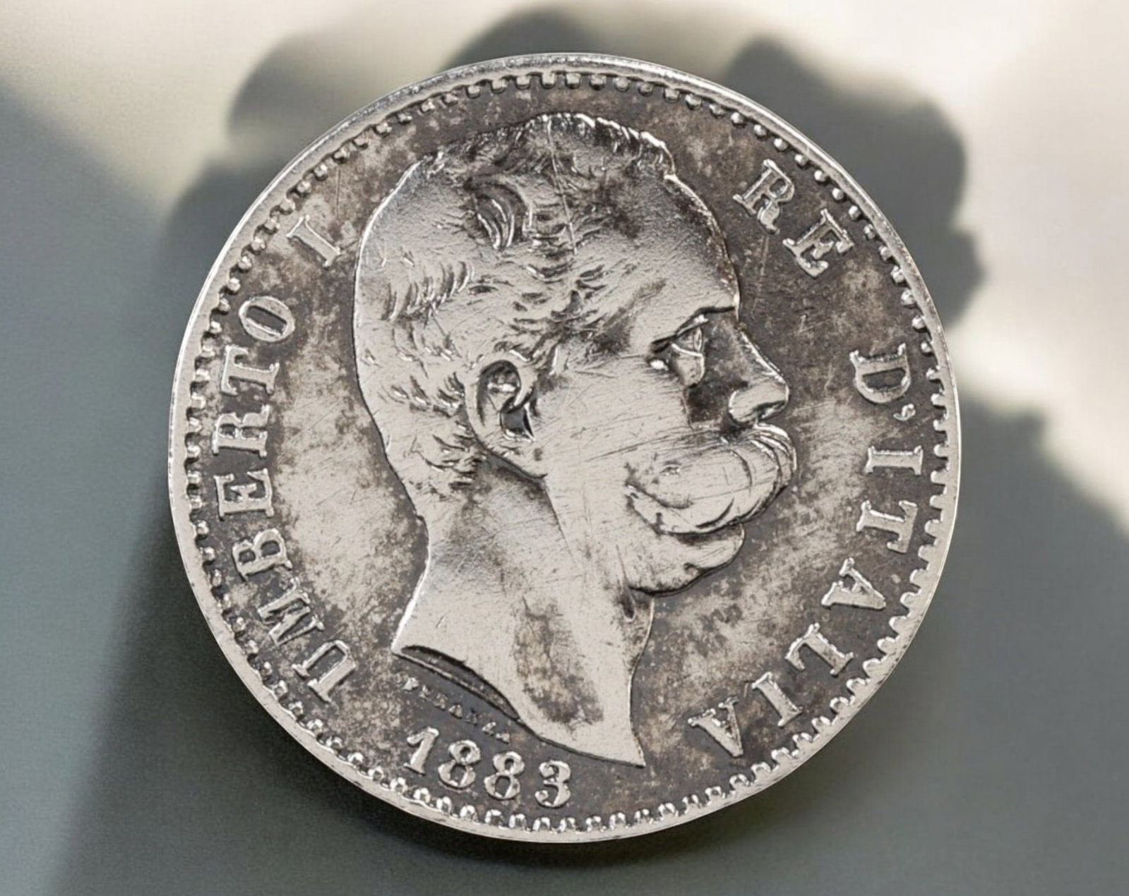 ITALY: Umberto I Silver 2 Lire Coin - 1883, Rome Mint: A classic silver 2 Lire coin from the reign of King Umberto I of Italy, struck in 1883 at the Rome Mint. Measuring 26.7mm in diameter and weighing 9.73g, this piece features a right-facing portrait of