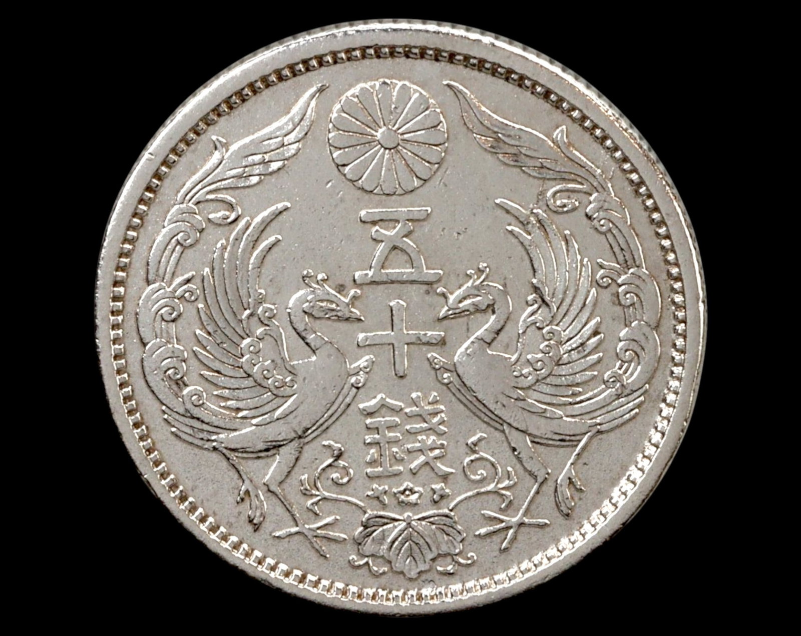 JAPAN: Taisho Era - 50 Sen, Year 12 (1923), Silver Coin: A 50 Sen coin from the 12th year of the Taisho era (1923), struck in silver during the reign of Emperor Taisho (1912-1926). The obverse features an exquisite depiction of two facing phoenixes, surroun