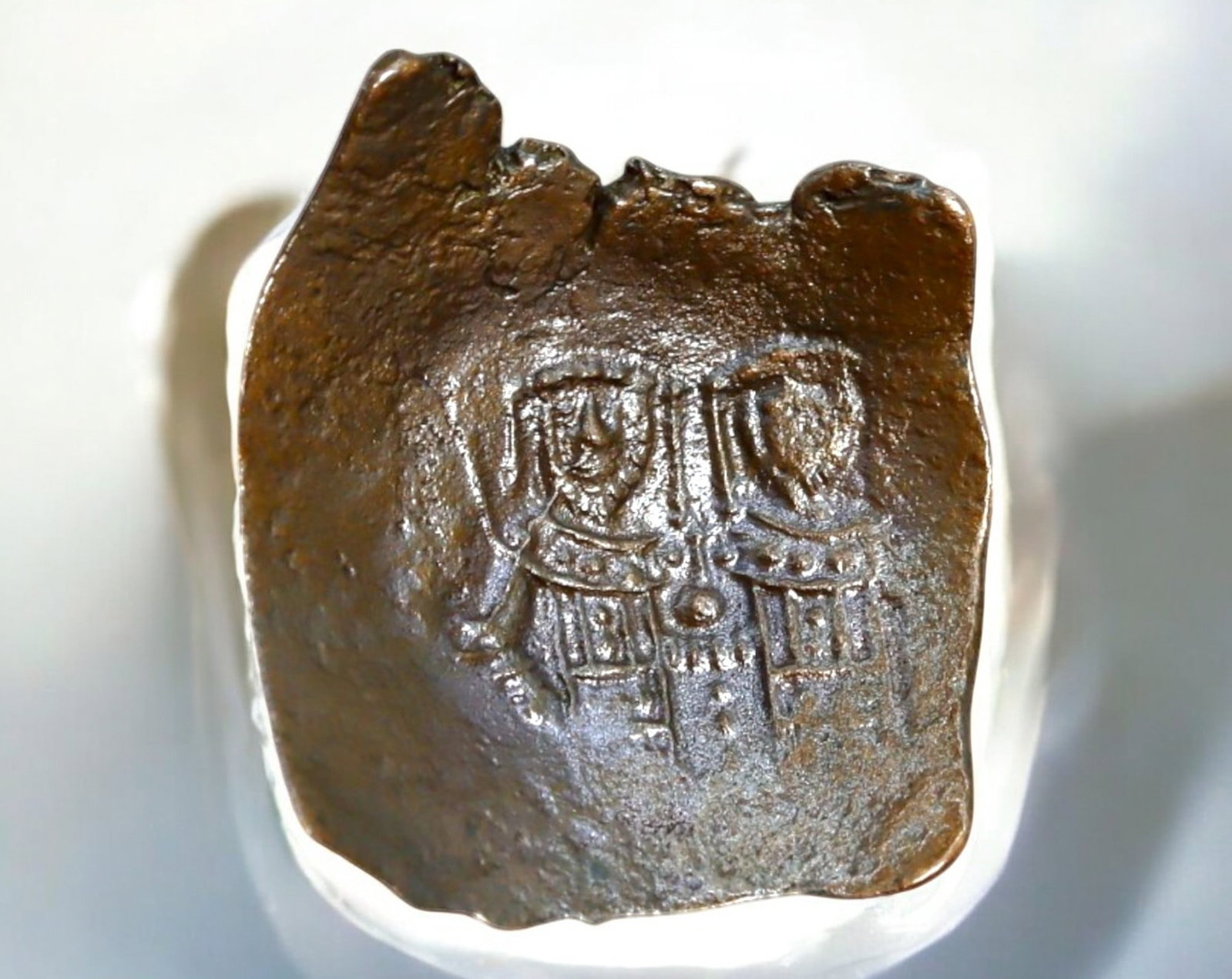 BYZANTINE EMPIRE: Late Byzantine AE Trachy, 12th-14th Century: A bronze Trachy (cup-shaped coin) from the Late Byzantine Empire, measuring 21x22mm and weighing 3.1g. The obverse features a double-figure depiction, possibly Christ or the Virgin Mary alongside an e