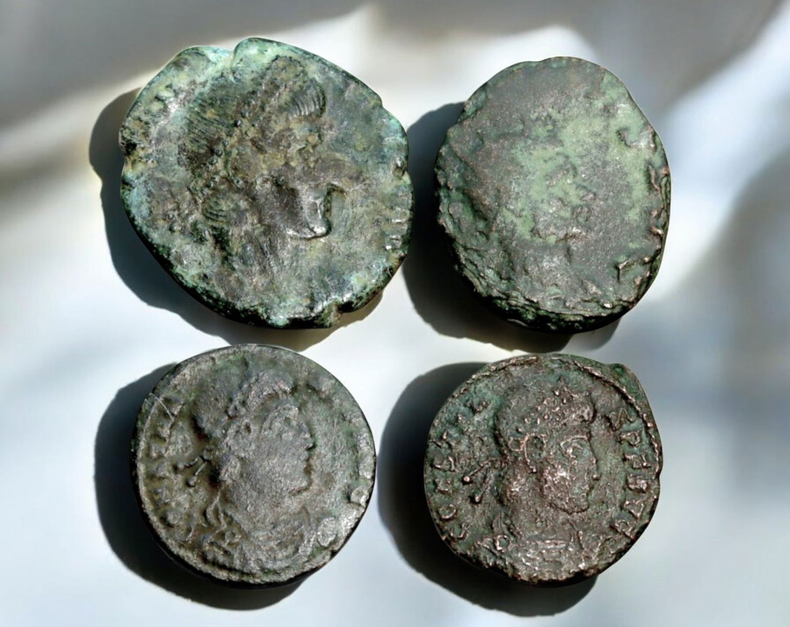 ROMAN EMPIRE: AE Coins - Bronze Coins, 15-19mm, 9.8g (Lot of 4): A collection of four ancient Roman bronze coins, each featuring a distinct imperial portrait on the obverse and various symbolic or military-themed reverses. These coins, essential to Roman commerce a