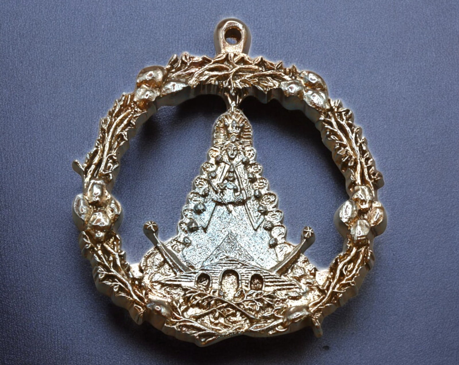 SPAIN: Virgen del Rocio Openwork Devotional Medal - Bronze, 19th-20th Century: A beautifully designed openwork bronze devotional medal, measuring 6.5x7.2 cm and weighing 43g, dedicated to the Virgen del Rocio. The circular frame is intricately adorned with floral and laurel moti