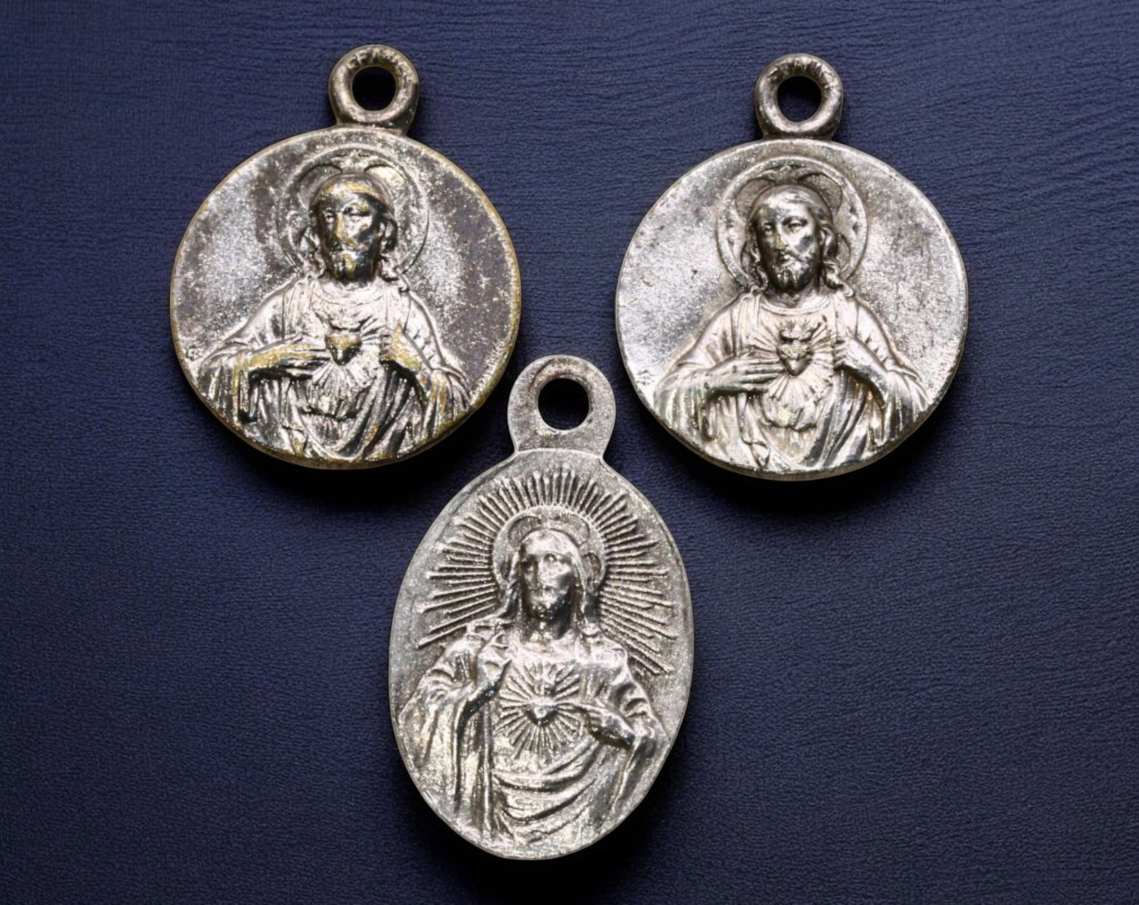 FRANCE: Lot of Three Silver Religious Medals - Sacred Heart & Sacr?-C?ur Basilica, 19th-20th Century: A beautifully detailed set of three silver devotional medals, ranging in size from 1.3 to 1.6 cm and weighing a combined 1.9g, each celebrating Catholic devotion to the Sacred Heart of Jesus and the f