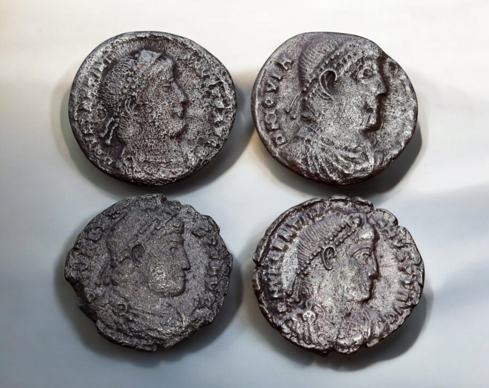 ROMAN EMPIRE: AE Coins - Bronze Coins, 18-19mm, 8.1g (Lot of 4): A collection of four ancient Roman bronze coins, each featuring a distinct imperial portrait on the obverse and various symbolic or military-themed reverses. These coins, essential to Roman commerce a