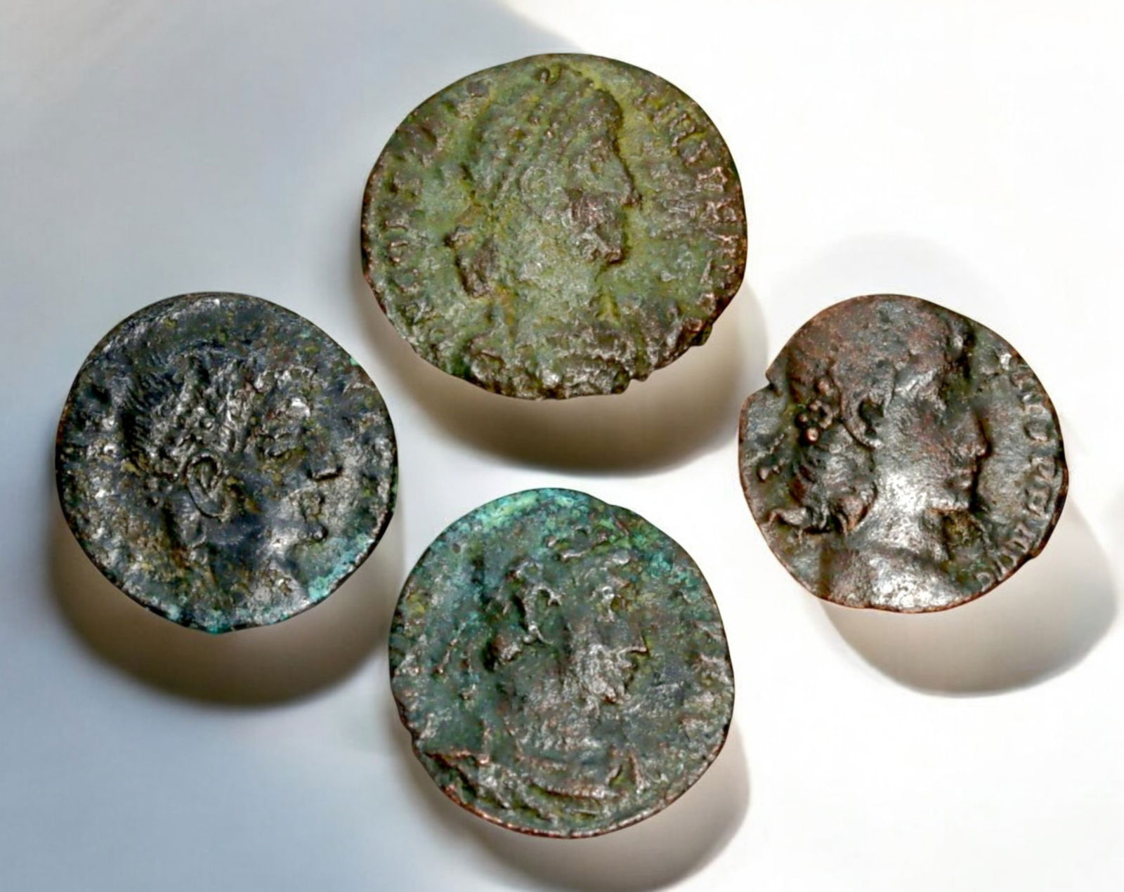ROMAN EMPIRE: AE Coins - Bronze Coins, 13-15mm, 5.7g (Lot of 4): A collection of four ancient Roman bronze coins, each featuring a distinct imperial portrait on the obverse and various symbolic or military-themed reverses. These coins, essential to Roman commerce a