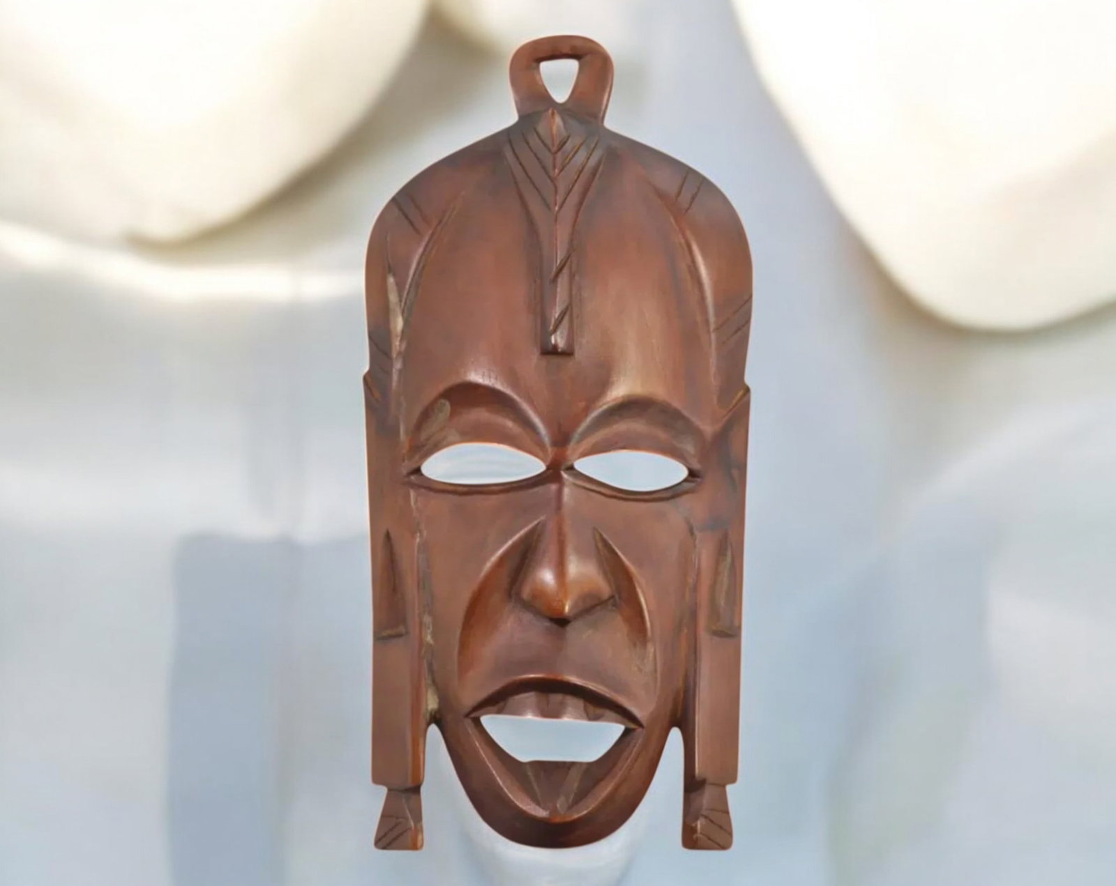 AFRICAN: Hand-Carved Wooden Tribal Mask (384g, 26x13cm): This intricately hand-carved wooden mask exemplifies the artistic traditions of African tribal craftsmanship. With bold geometric patterns and expressive features, the mask is both striking and symbol