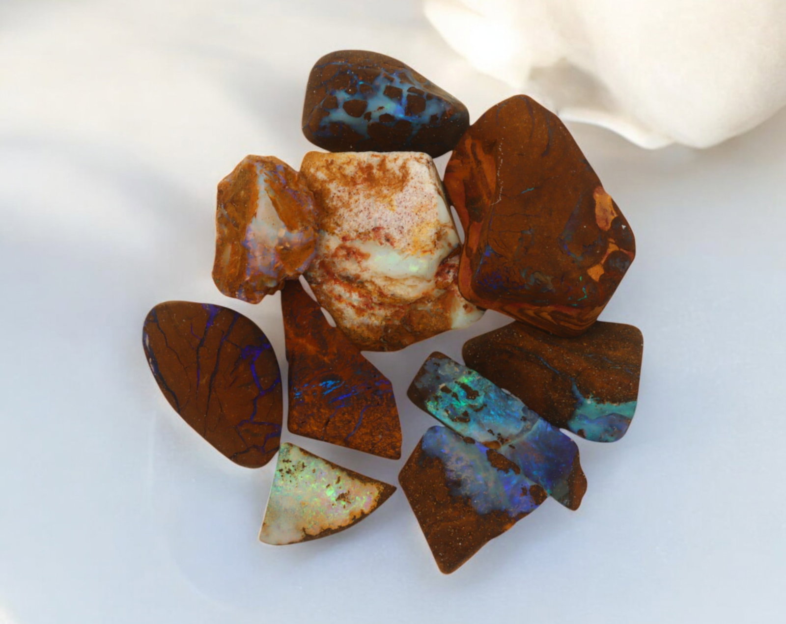 AUSTRALIAN MATRIX BOULDER OPAL - Rough Lot, 23g, 1-2.5cm (Images Taken Wet): A striking lot of natural Australian matrix boulder opal rough. These raw specimens display mesmerizing flashes of blue, green, and gold veins running through ironstone, characteristic of high-quality