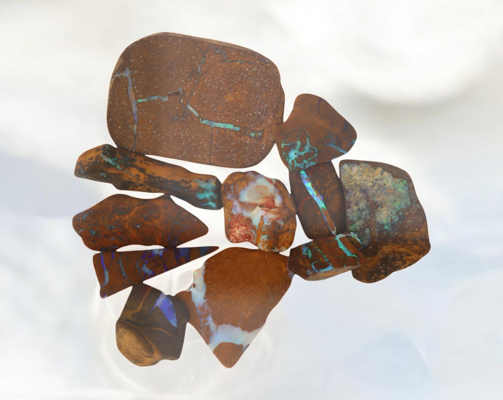 AUSTRALIAN MATRIX BOULDER OPAL - Rough Lot, 36g, 1-3cm (Images Taken Wet): A striking lot of natural Australian matrix boulder opal rough. These raw specimens display mesmerizing flashes of blue, green, and gold veins running through ironstone, characteristic of high-quality