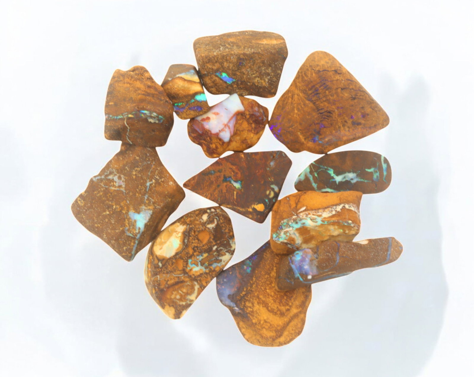 AUSTRALIAN MATRIX BOULDER OPAL - Rough Lot, 33g, 1-2.8cm (Images Taken Wet): A striking lot of natural Australian matrix boulder opal rough. These raw specimens display mesmerizing flashes of blue, green, and gold veins running through ironstone, characteristic of high-quality