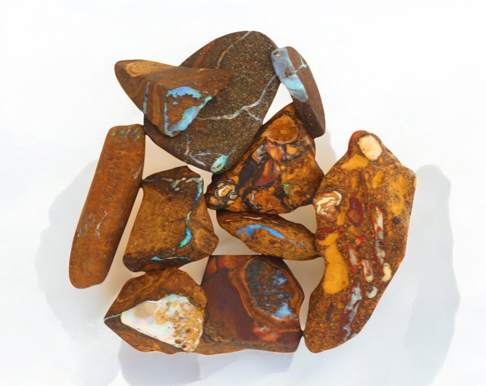 AUSTRALIAN MATRIX BOULDER OPAL - Rough Lot, 69g, 1-4.7cm (Images Taken Wet): A striking lot of natural Australian matrix boulder opal rough. These raw specimens display mesmerizing flashes of blue, green, and gold veins running through ironstone, characteristic of high-quality
