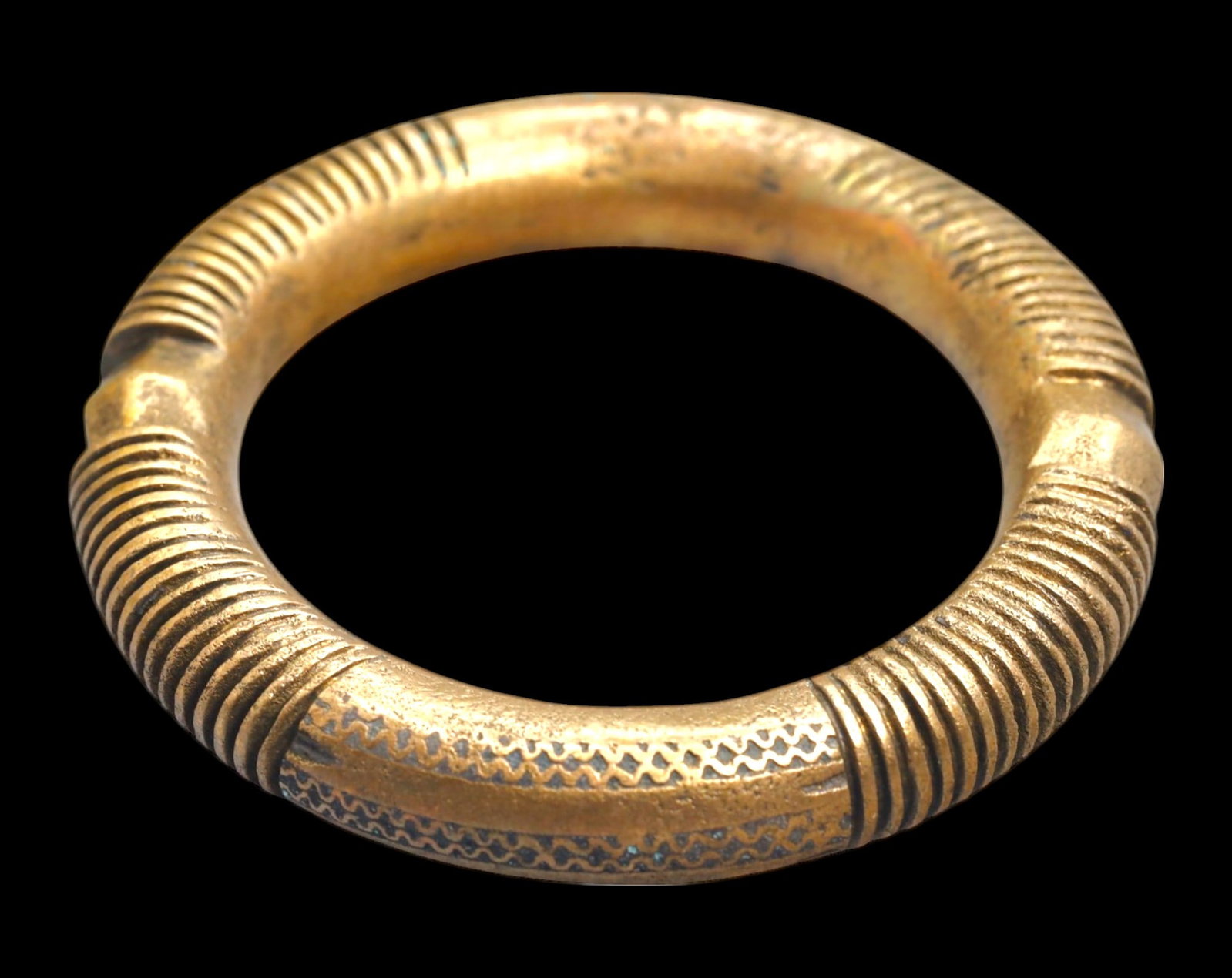 This substantial bronze currency bracelet, measuring 2x8cm and weighing 79g, showcases a: A finely crafted bronze currency bracelet from West Africa, measuring 1.4x8.7cm and weighing 263g. The piece features intricate linear and geometric engravings encircling its surface, with raised ridg