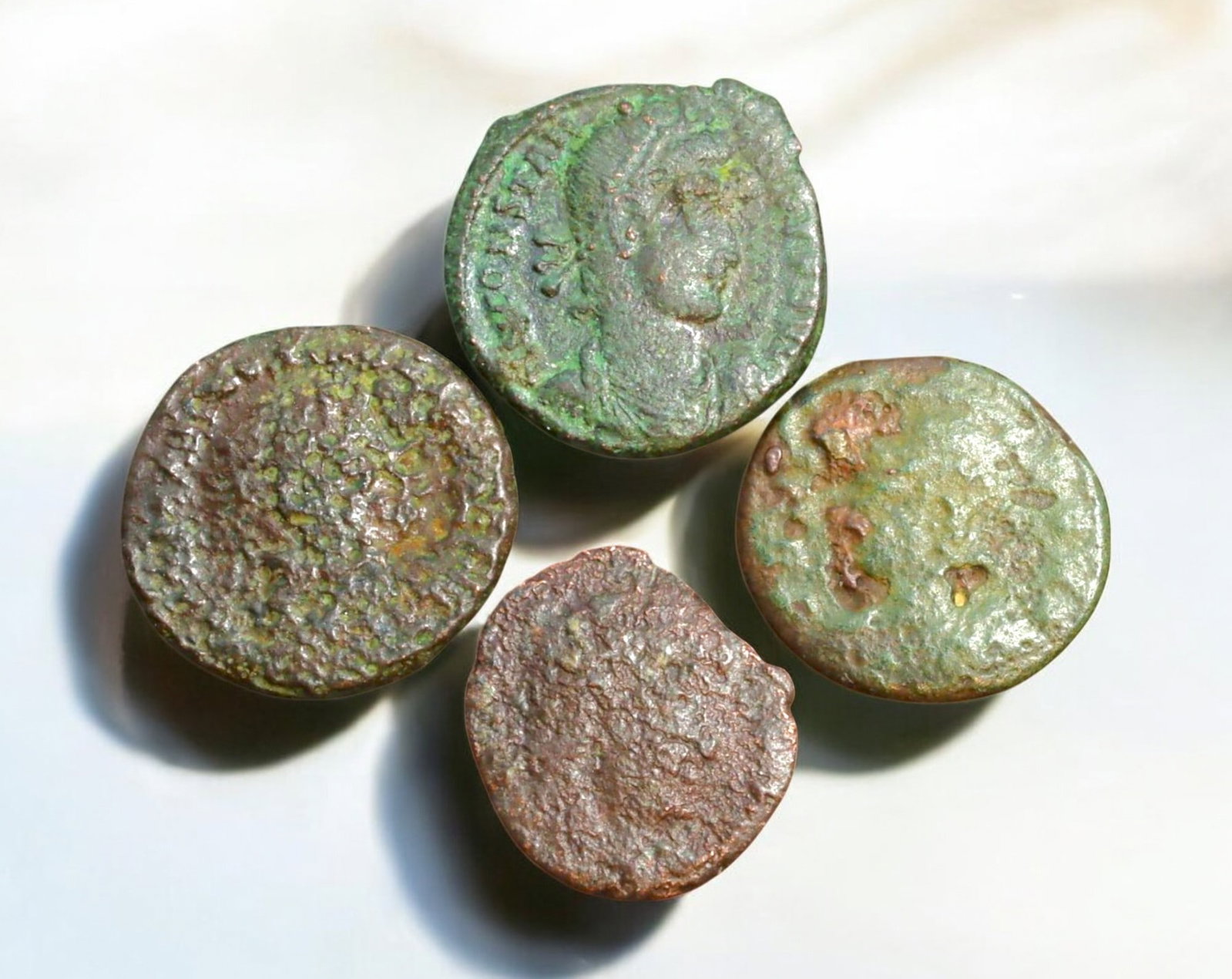 ROMAN EMPIRE: AE Coins - Bronze Coins, 15-18mm, 8.7g (Lot of 4): A collection of ancient Roman bronze coins, each featuring a distinct imperial portrait on the obverse and various symbolic or military-themed reverses. These coins, essential to Roman commerce and go
