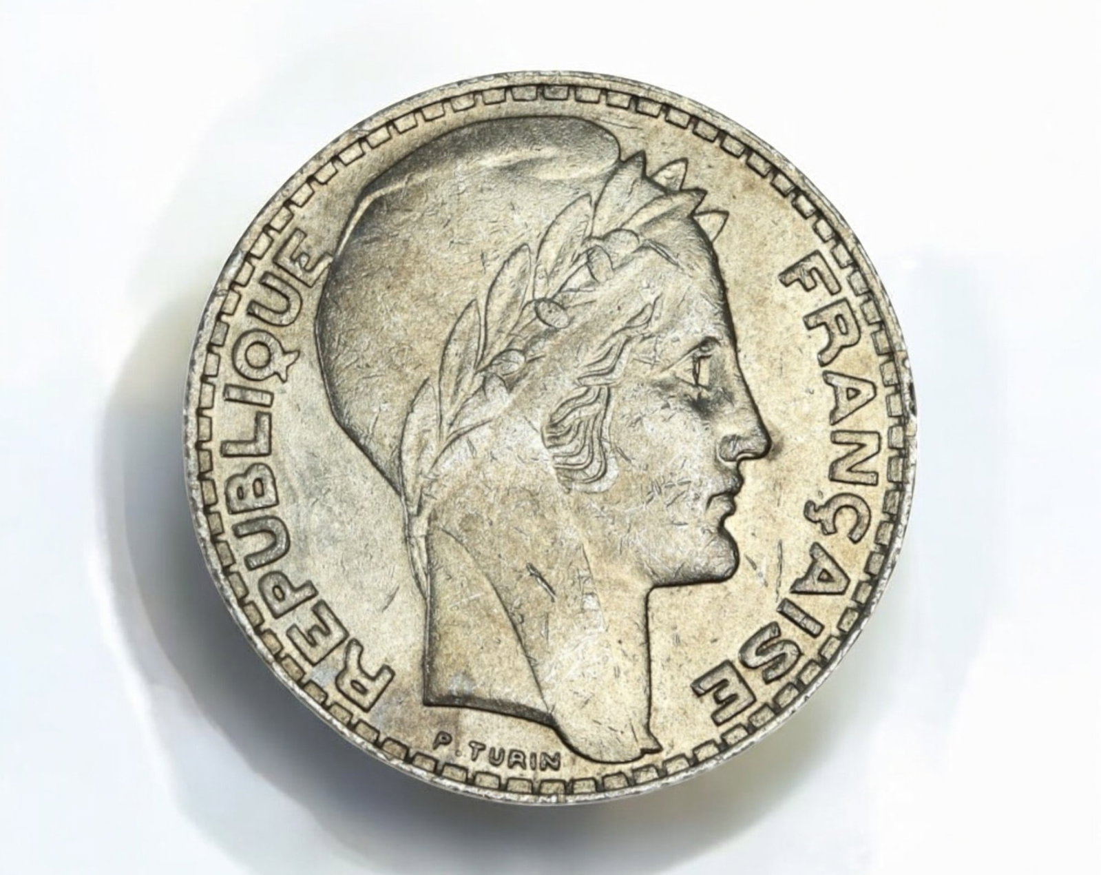 FRANCE: 10 Francs Coin - Republic, Nickel, 2.7cm, 10g, 1929-1939: A French 10 Francs Coin coin from the Third Republic (1870-1940), struck in nickel, measuring 2.7 cm in diameter and weighing 10g. The obverse features a striking depiction of Marianne, the national s
