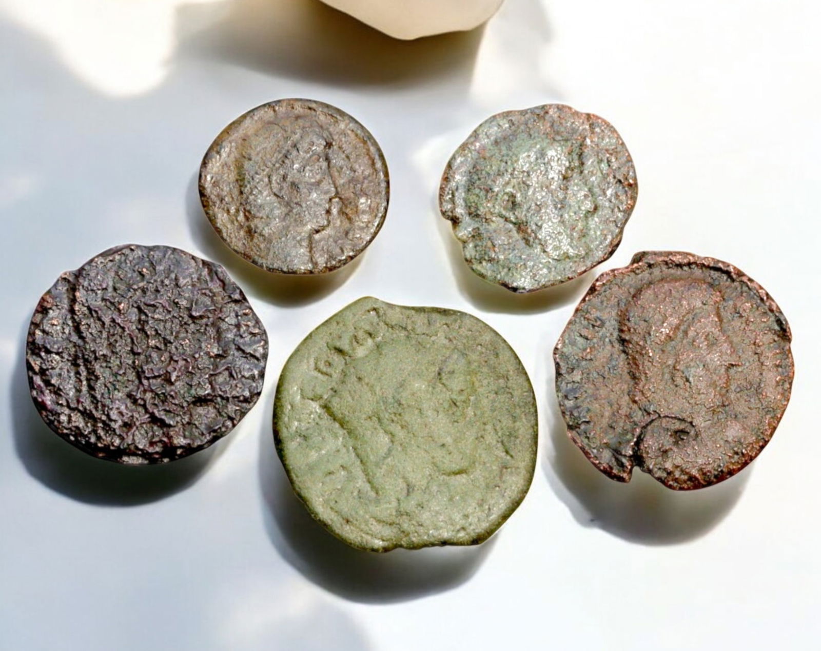 ROMAN EMPIRE: AE Coins - Bronze Coins, 13-19mm, 10.5g (Lot of 5): A collection of five ancient Roman bronze coins, each featuring a distinct imperial portrait on the obverse and various symbolic or military-themed reverses. These coins, essential to Roman commerce a