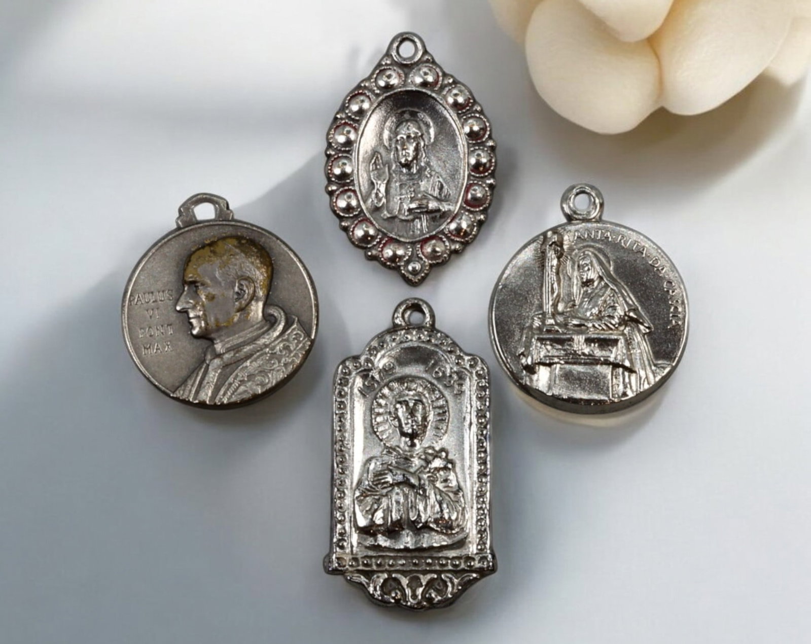 VATICAN: Lot of Four Religious Medals - Silver-Tone, 1.8-2.6cm, 9.2g Total: A collection of four silver-tone religious medals, ranging from 1.8cm to 2.6cm in size and weighing a total of 9.2g, featuring detailed imagery of Catholic saints and figures. The set includes a medal