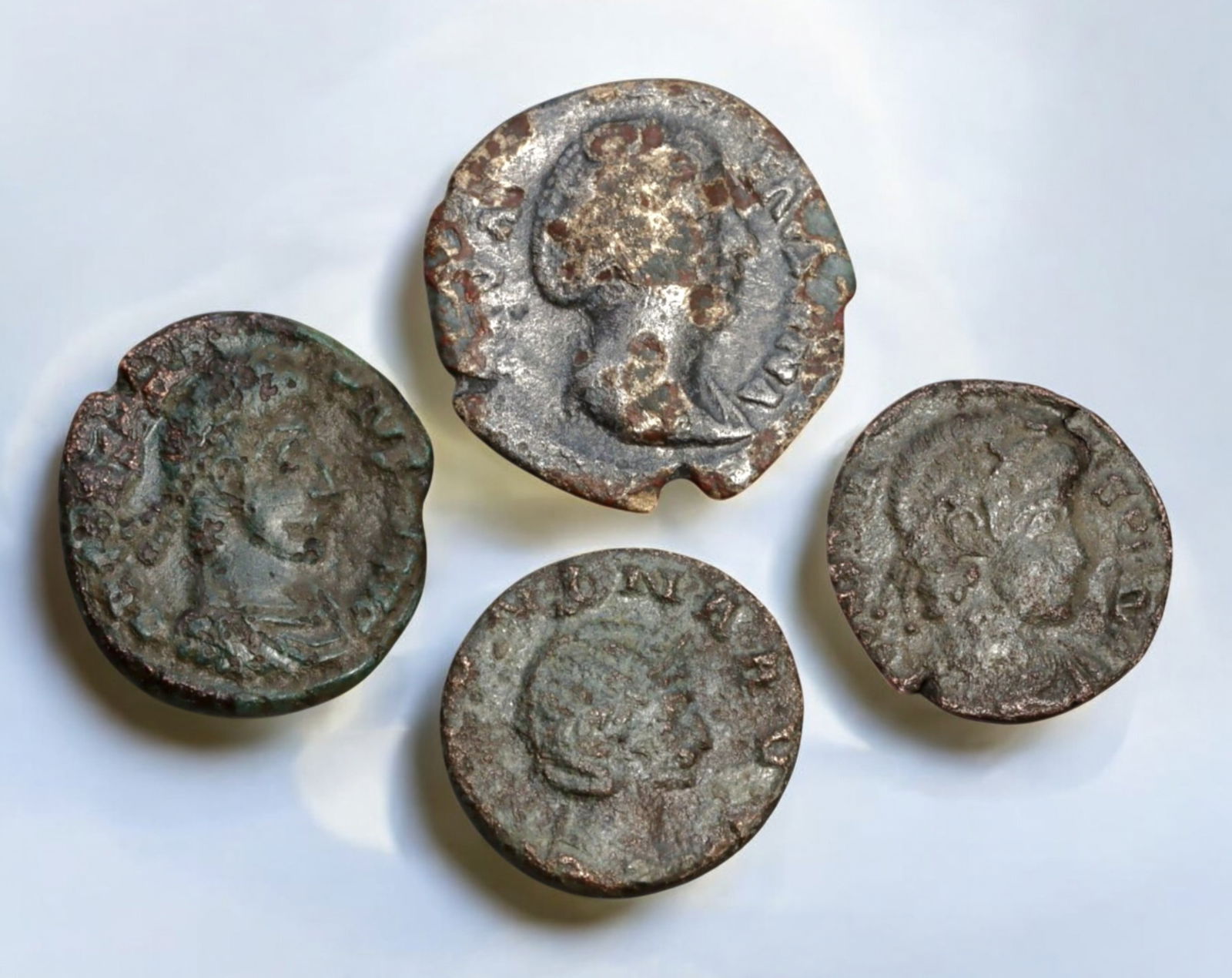 ROMAN EMPIRE: AE Coins - Bronze Coins, 15-19mm, 9.8g (Lot of 4): A collection of four ancient Roman bronze coins, each featuring a distinct imperial portrait on the obverse and various symbolic or military-themed reverses. These coins, essential to Roman commerce a