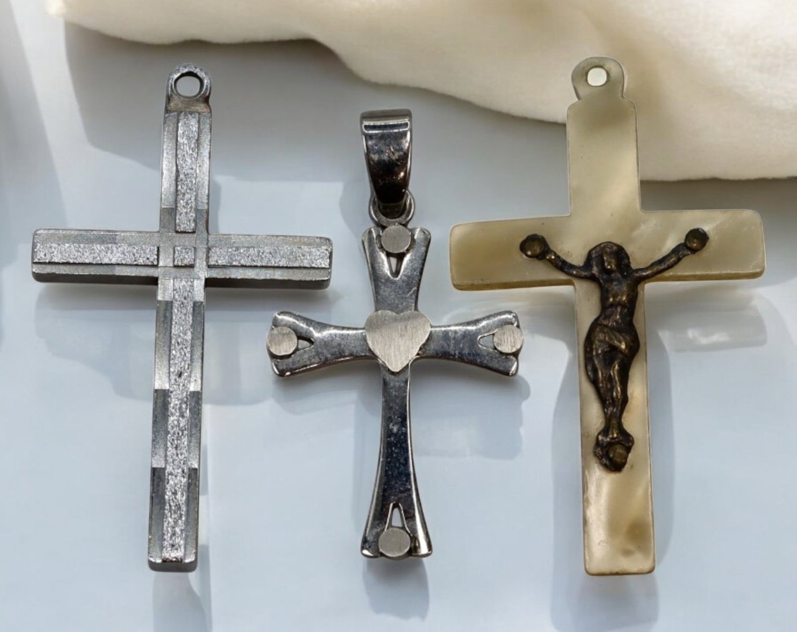 EUROPE: Antique Religious Crosses - 3pcs, 6g, 3-3.5cm, 20th Century: A trio of antique crosses, each measuring between 3 to 3.5 cm with a total weight of 6 grams. The set features a mix of metal and mother-of-pearl-like materials, with one cross showcasing a raised fig