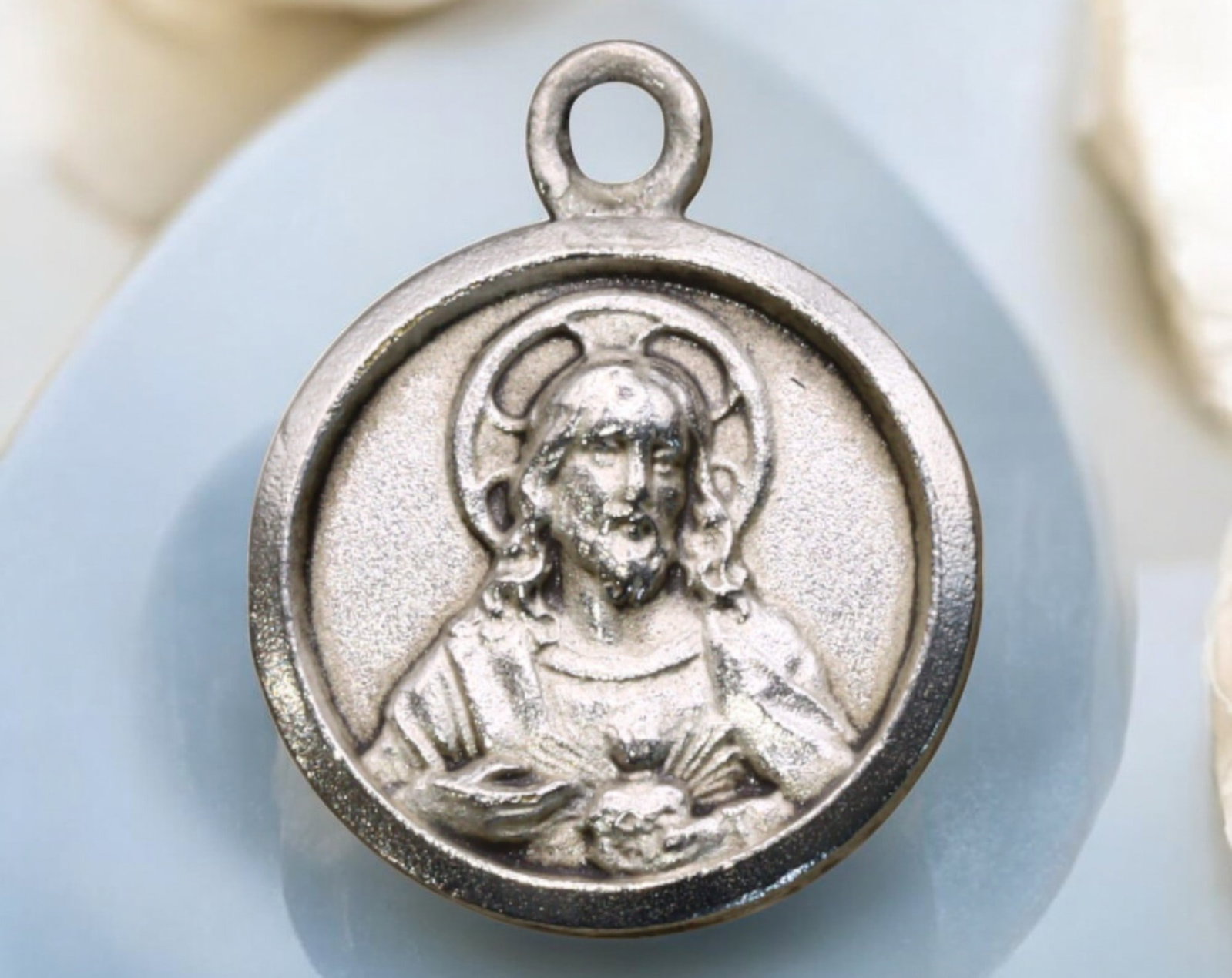 FRANCE: Silver Medal Coin - Sacred Heart of Jesus & Basilica of Sacre-Coeur, Montmartre: A delicate silver devotional medal featuring the Sacred Heart of Jesus on the obverse, depicted in high relief with a radiant halo and a compassionate gaze, hands pointing to His heart as a symbol of 
