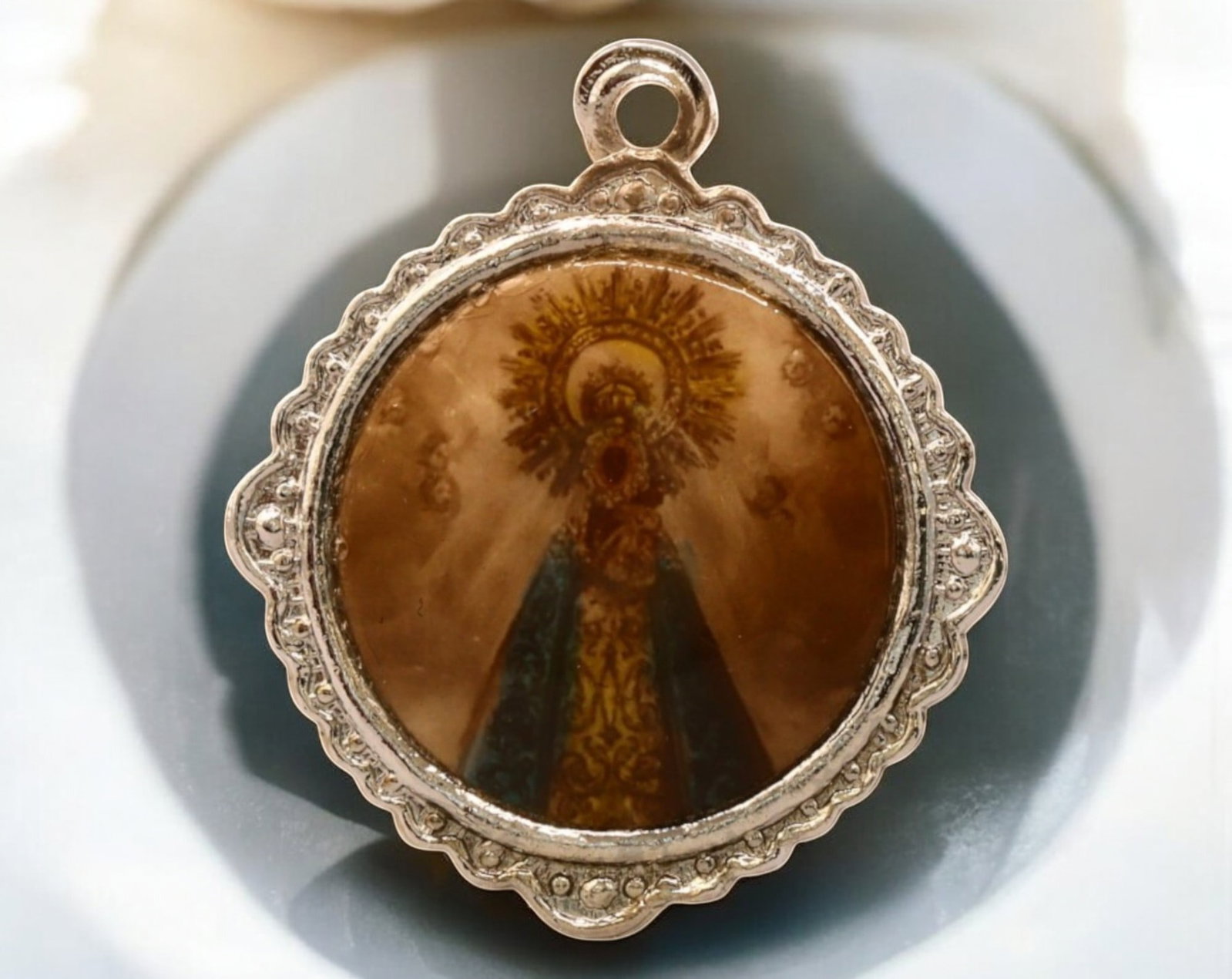 SPAIN: Silver-Plated Devotional Medal - Our Lady of Sorrows, 20th Century, 4.6g, 23mm: A beautifully crafted silver-plated devotional medal featuring an intricate image of Our Lady of Sorrows, adorned in a richly detailed mantle with a radiant halo. Encased within an ornate scalloped bo