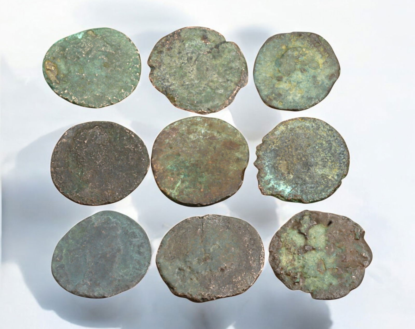 ROMAN EMPIRE: AE Coins - Bronze Coins, 15mm, 13g (Lot of 9): A collection of four ancient Roman bronze coins, each featuring a distinct imperial portrait on the obverse and various symbolic or military-themed reverses. These coins, essential to Roman commerce a