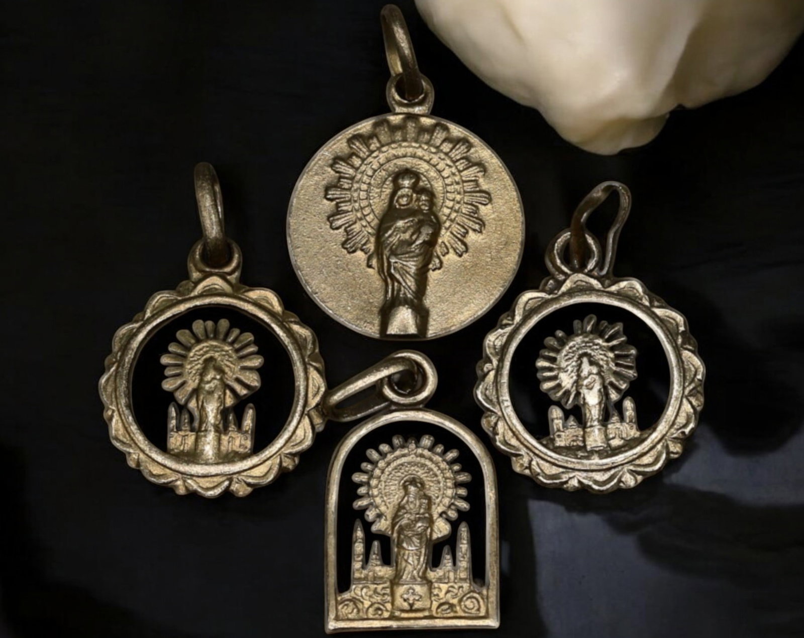 SPAIN: Our Lady of the Pillar Silver-Tone Medal Set - Zaragoza Devotional Tokens (4 Pieces): A remarkable set of four silver-tone devotional medals honoring Nuestra Se?ora del Pilar (Our Lady of the Pillar), the patroness of Spain and Zaragoza. Each piece features a distinct cutout or engrave