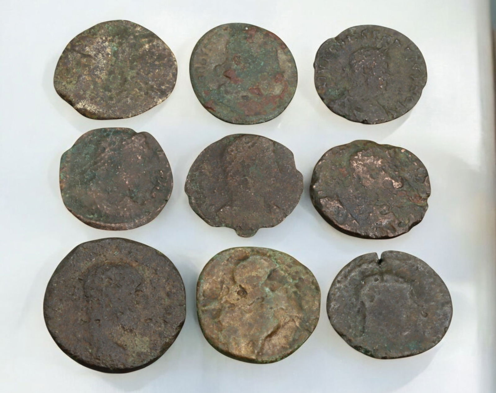 ROMAN EMPIRE: AE Coins - Bronze Coins, 15-20mm, 20g (Lot of 9): A collection of four ancient Roman bronze coins, each featuring a distinct imperial portrait on the obverse and various symbolic or military-themed reverses. These coins, essential to Roman commerce a