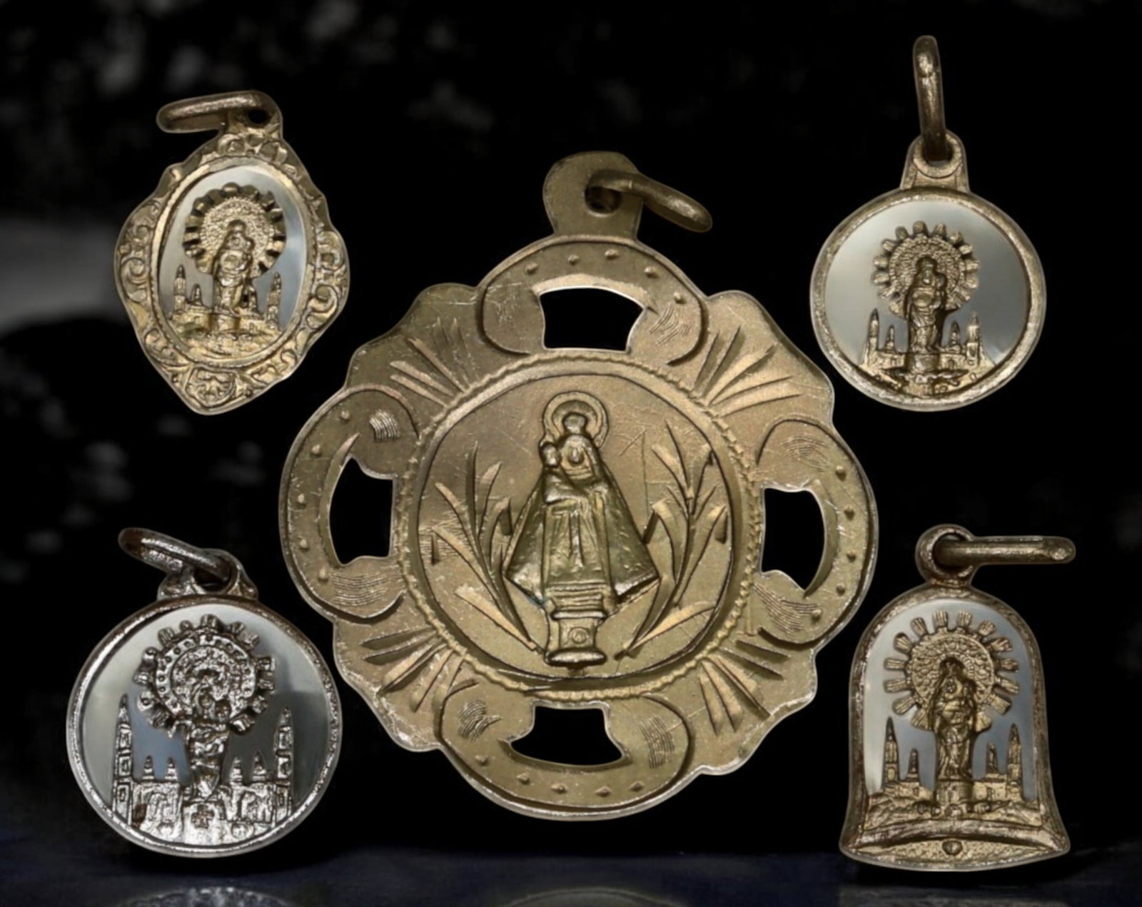 SPAIN: Set of Five Devotional Medals - Silver-Tone, Our Lady of the Pillar, 19th-20th Century: A set of five devotional medals, ranging from 1.5 to 3.6 cm and weighing 6.7g, crafted in silver-tone metal and intricately designed. The central and largest medal features Our Lady of the Pillar, the